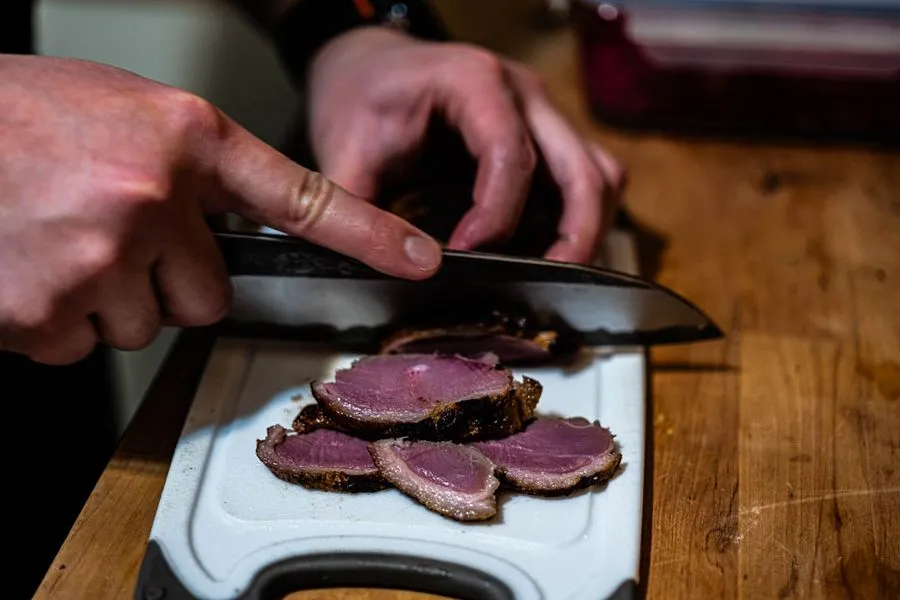 Miso-cured duck breast sliced thin on a bias revealing a rosy pink center and golden crispy skin