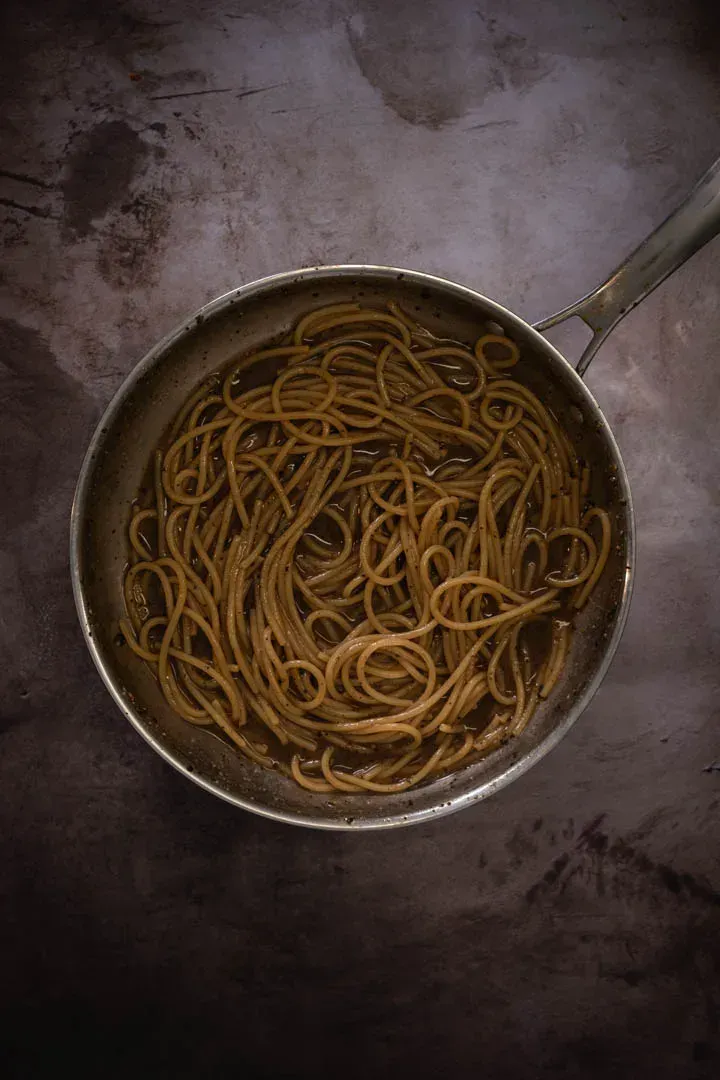Instructions 6: Transfer drained pasta directly to the pepper sauce using tongs, adding more pasta water as needed.