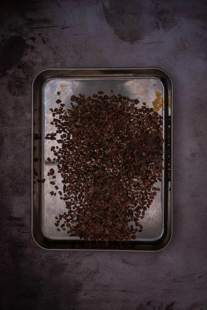 Cacao nibs spread on a baking tray, toasted until shiny and fragrant