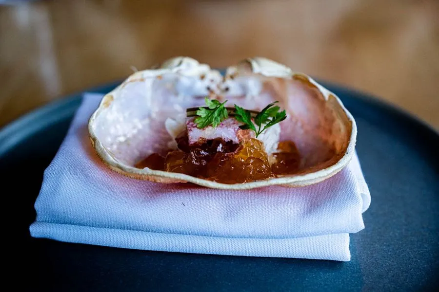 Crab with dashi broth and tomatillo at Hoogan et Beaufort Montreal, delicate seafood arranged in a shallow bowl with precise, minimalist plating