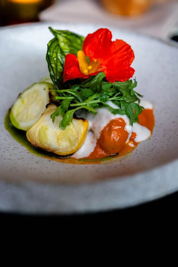 Second course at Île Flottante Montreal tasting menu, a vegetable-forward seasonal plate with clean, confident plating