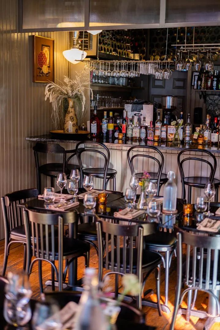 Intimate dining room at Île Flottante Montreal with warm, flattering lighting and tables set for a calm, unhurried evening