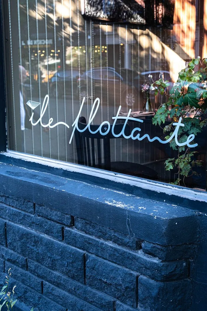 Elegant plating at Île Flottante Montreal, a delicate seasonal dish resting on fine ceramic in the intimate Mile End dining room