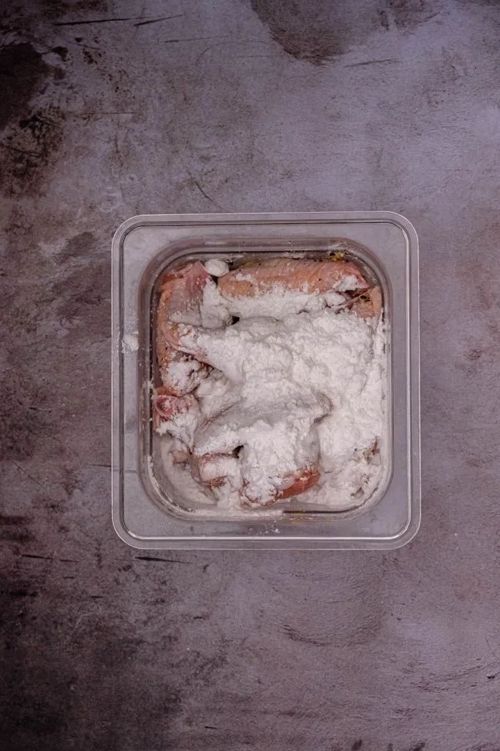 Instructions 4: Put the potato starch on a plate. Roll each marinated wing in the starch until completely coated on all sides.