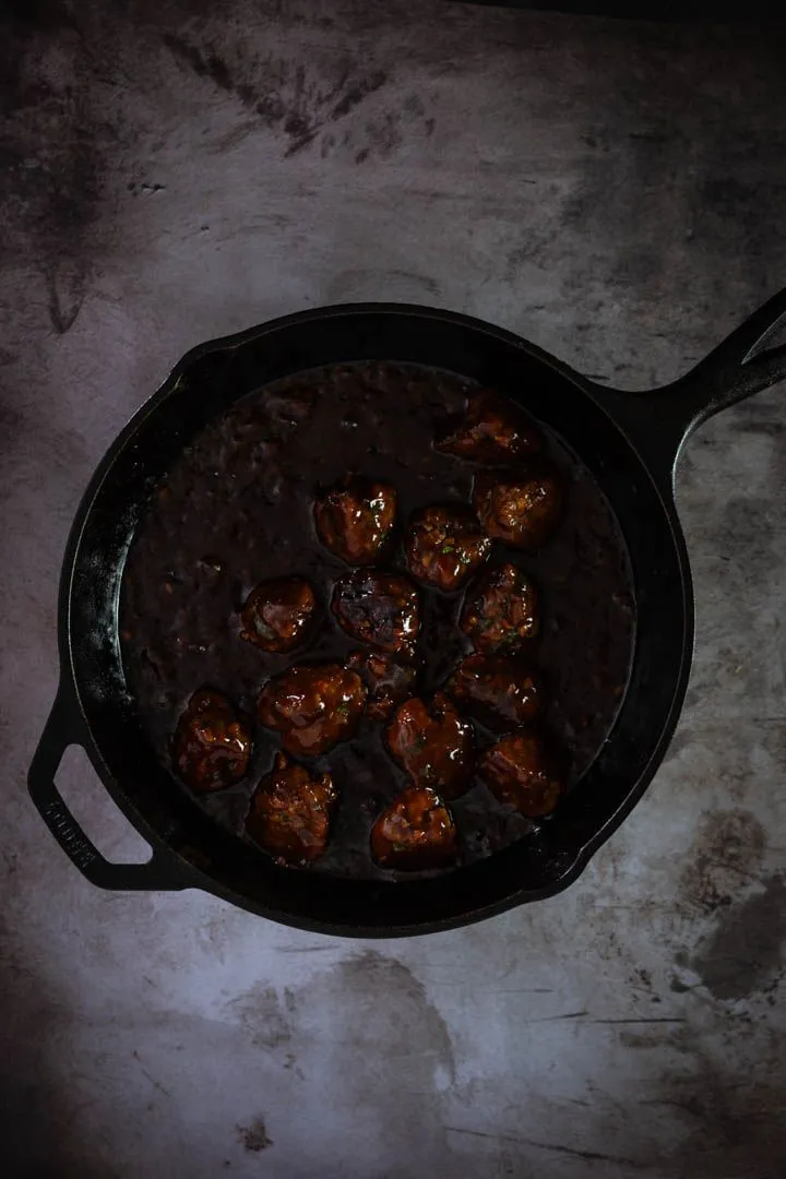 Glazed lamb meatballs tossed in sticky gochujang sauce, glistening and ready to plate over kabocha puree