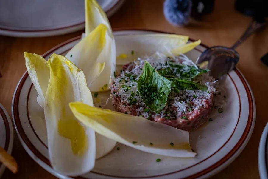 Zesty Italian beef tartare with endive leaves, fresh basil, shaved parmesan, and olive oil at McKiernan