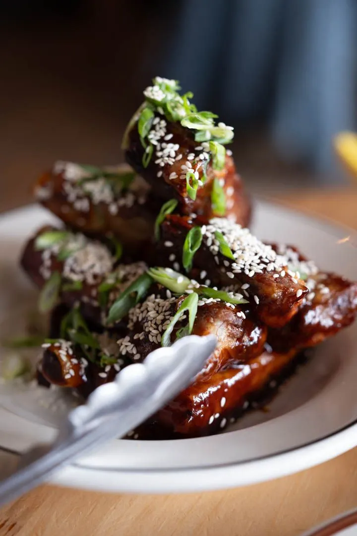 Honey garlic spare ribs glazed with sticky sauce, topped with sesame seeds and green onions at McKiernan
