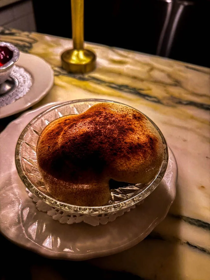 Baba tiramisu dessert with cocoa dusting in glass bowl at Moccione Montreal