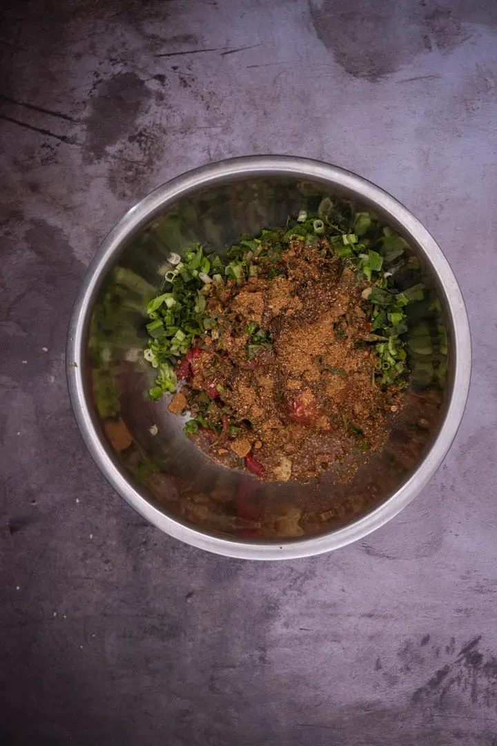 Instructions 2: Add the laab powder and garlic oil to the beef and mix until the powder coats the slices evenly. Add the fish sauce, lim