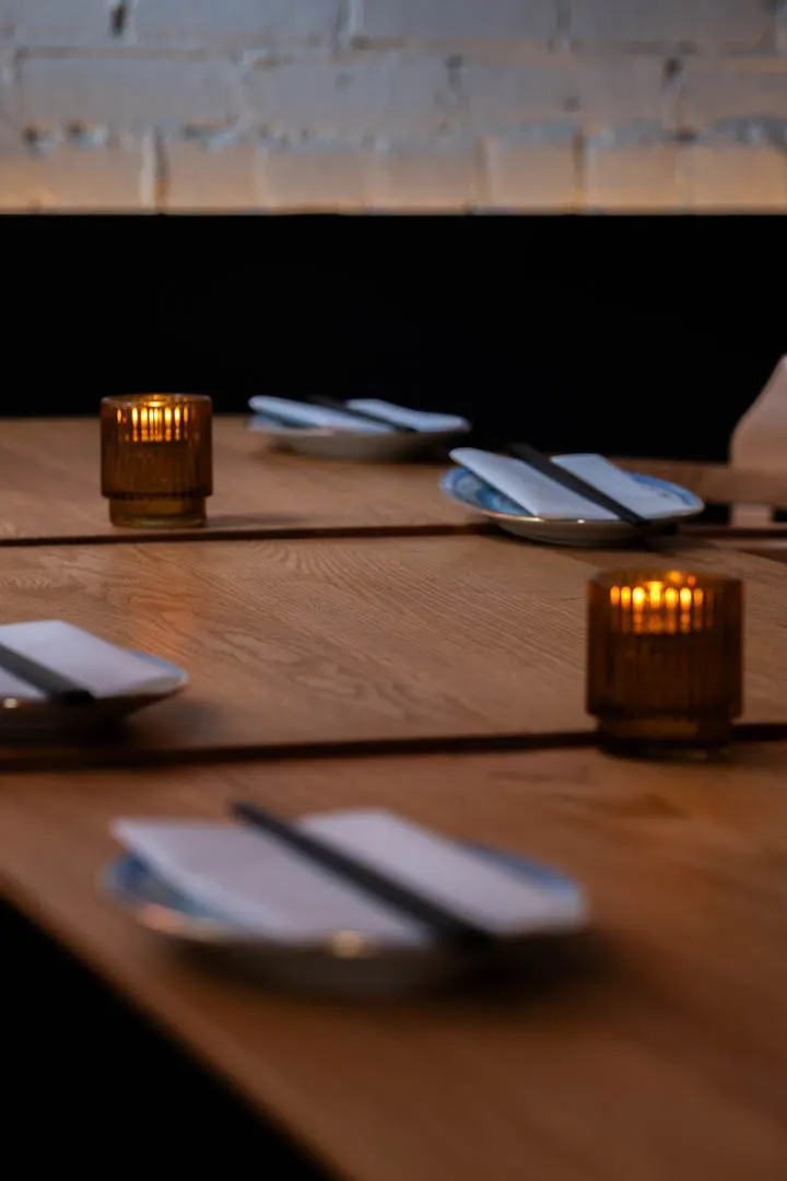 Elegant table setting at Oncle Lee Kăo Montreal with warm ambient lighting, clean lines, and the high-ceiling dining room in the background