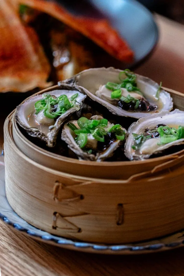 Steamed oysters with black bean sauce at Oncle Lee Kăo Montreal, clean and briny with a salty-sweet fermented depth that keeps the oyster fresh and complex