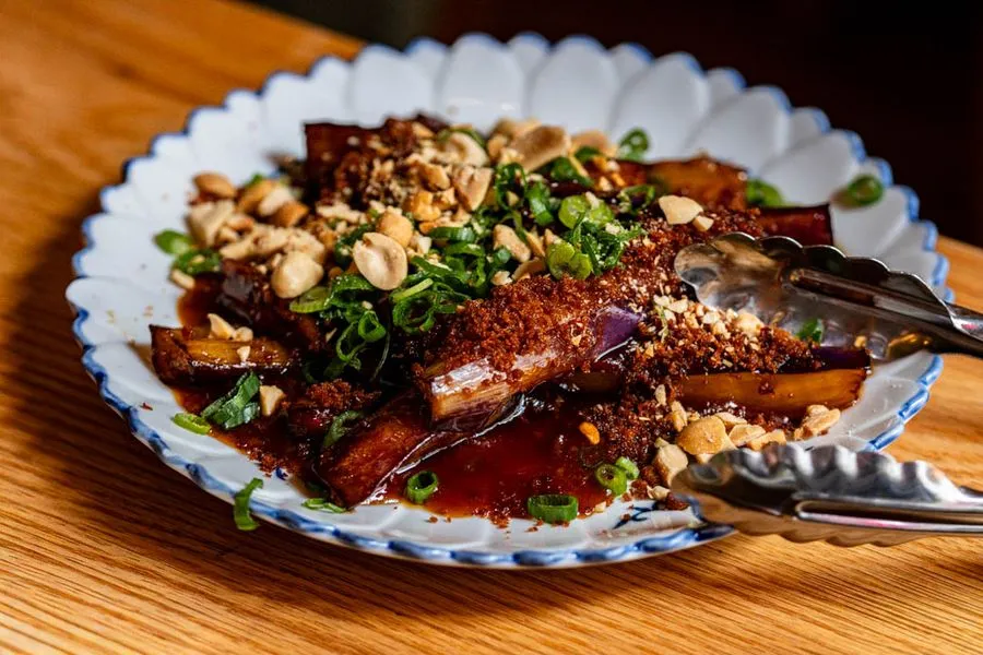 Sweet and sour eggplant with peanuts and bacon at Oncle Lee Kăo Montreal, glossy and jammy with a smoky salty anchor and crunch that makes the table come alive
