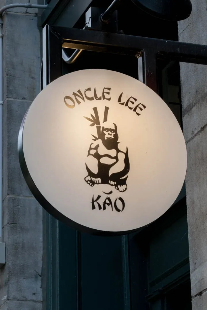 Oncle Lee Kăo's soaring dining room in Old Montreal, Michelin Bib Gourmand with burnt-orange leather accents and warm flattering lighting