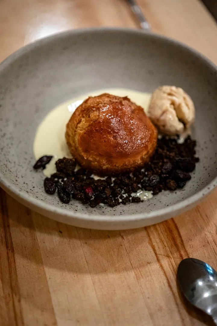 Baba dessert with black beets at Othym Montreal, a soaked cake with deep molasses-like sweetness from the black beet treatment, a complex and satisfying closer