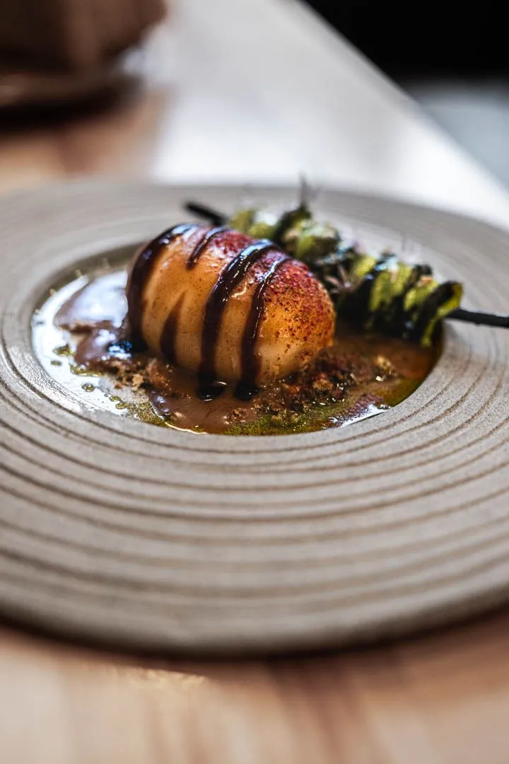 Fiddleheads with duck egg, crab bisque, and smoked breadcrumbs at Othym Montreal, a seasonal Quebec spring plate with bright green snap and savory crunch