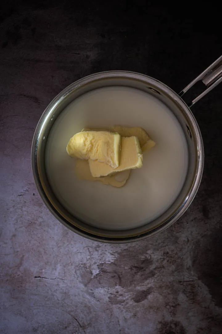 Smooth choux dough ball pulling away from the sides of a saucepan after flour has been stirred in