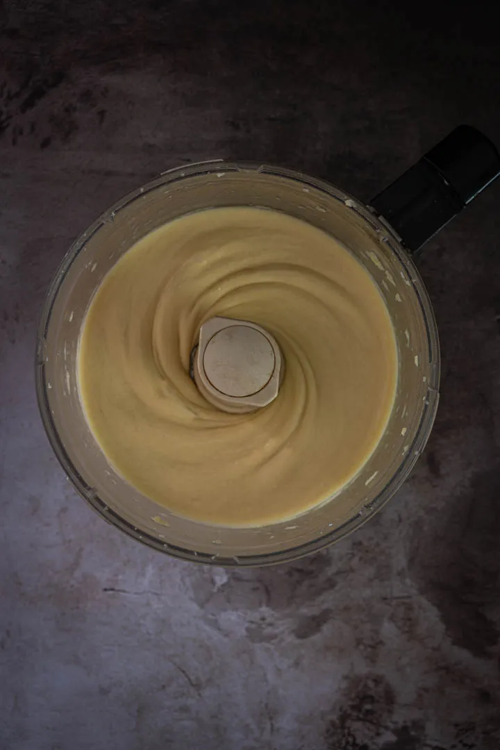 Glossy, smooth choux dough in food processor after eggs have been fully incorporated
