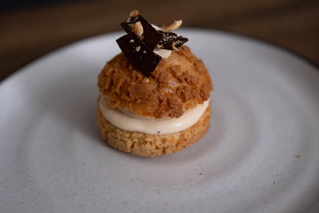 Golden choux pastry puffs arranged on a baking sheet, crisp shells with light, airy interiors visible