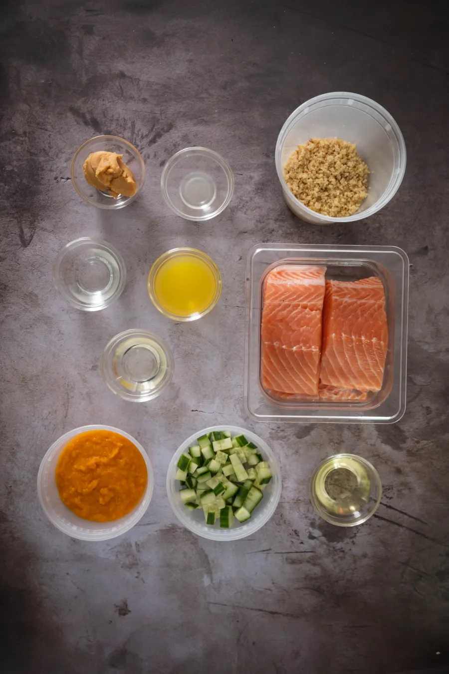 Key ingredients for quinoa-crusted salmon including salmon fillets, quinoa, miso paste, orange, and aji amarillo