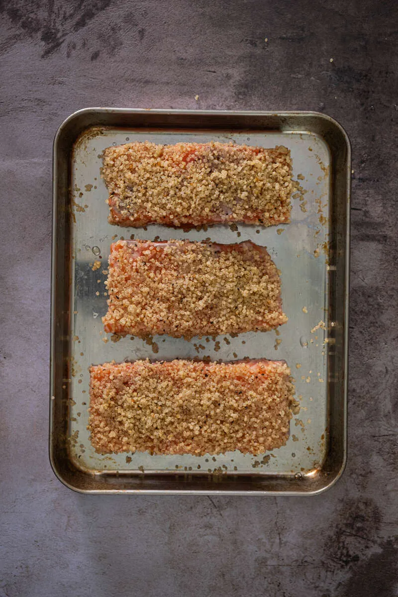 Instructions 2: Season cooked quinoa with salt and black pepper. Press quinoa evenly onto one side of each salmon fillet.
