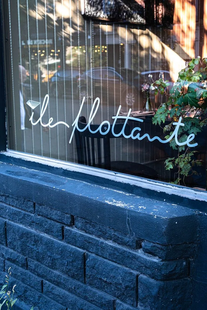 Elegant plating at Île Flottante Montreal, a delicate seasonal dish resting on fine ceramic in the intimate Mile End dining room