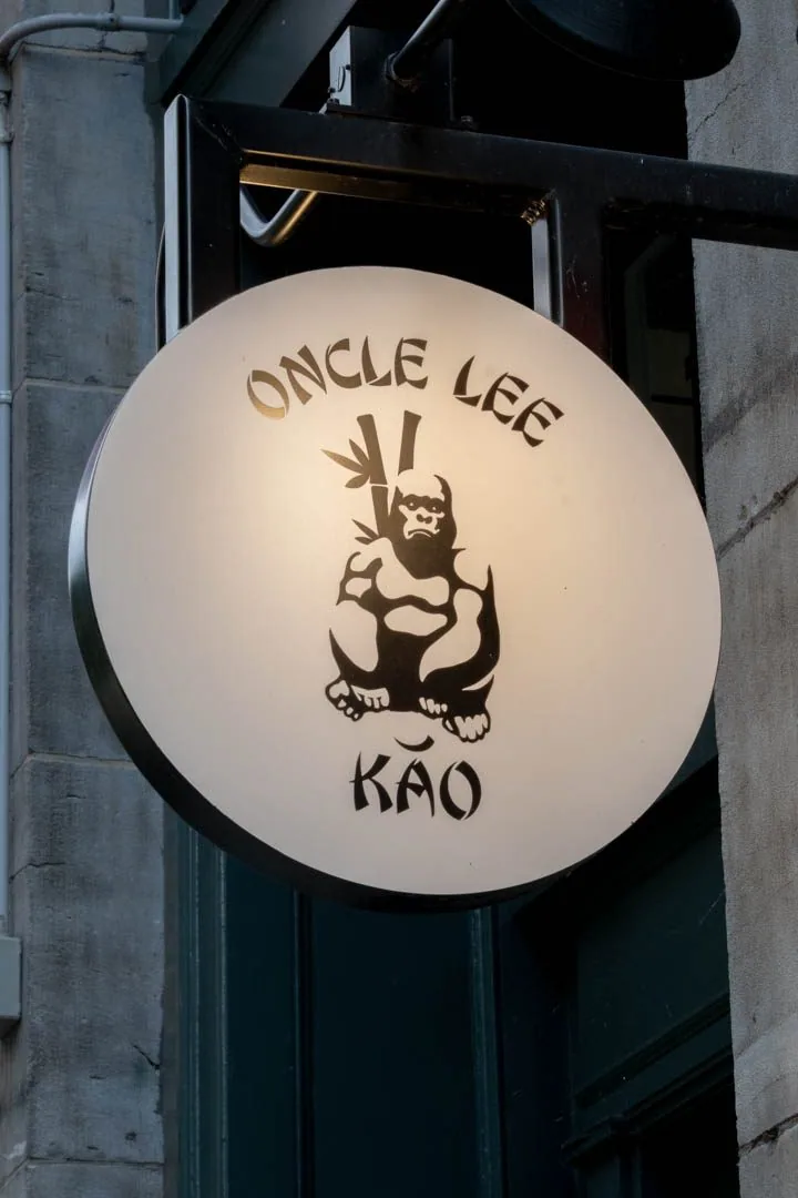 Oncle Lee Kăo's soaring dining room in Old Montreal, Michelin Bib Gourmand with burnt-orange leather accents and warm flattering lighting