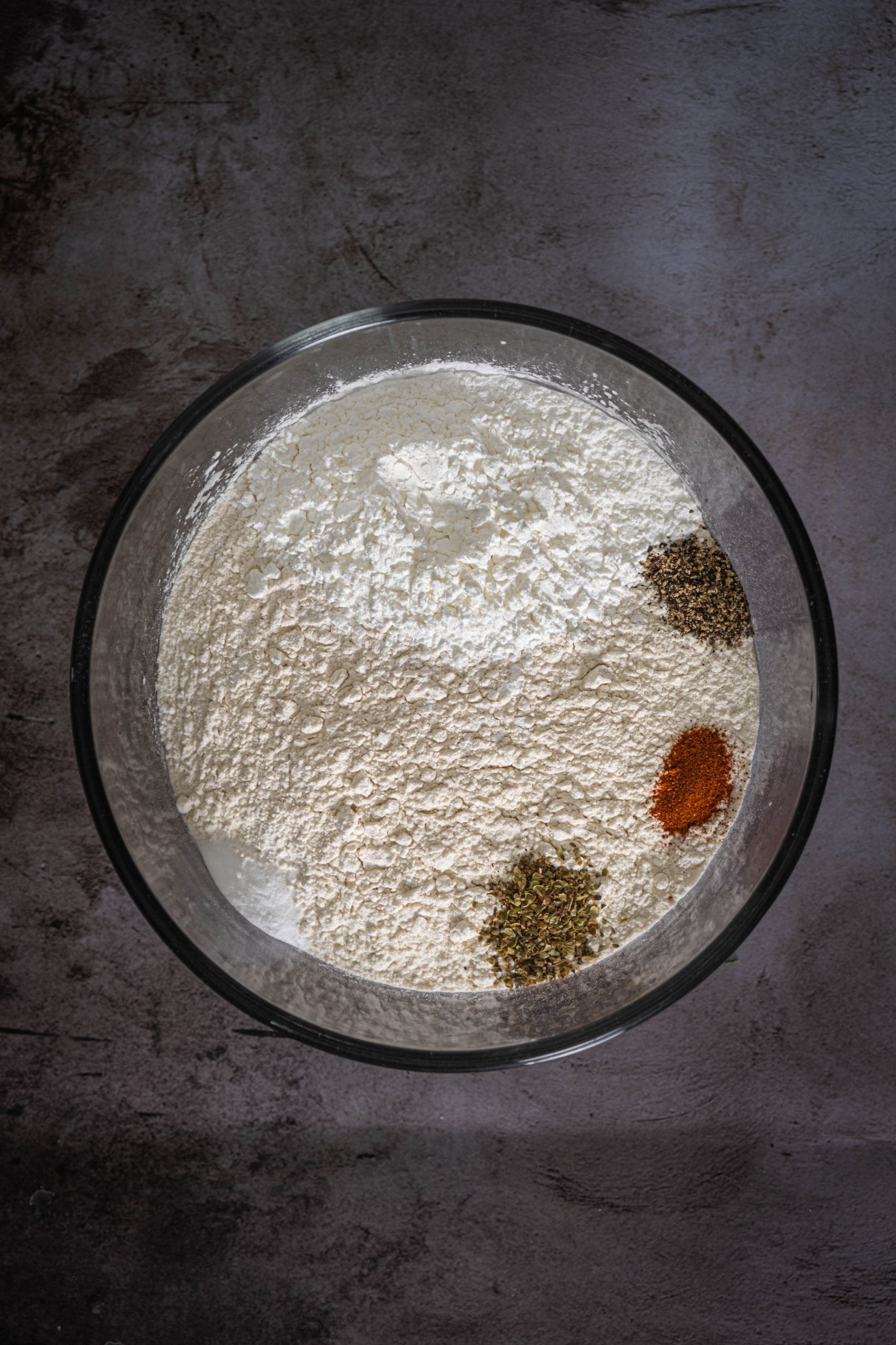 In a medium bowl, whisk together 1 1/2 cups all-purpose flour, 1/3 cup cornstarch, 1/2 teaspoon baking powder, 3/4 teaspoon dry oregano, 1/2 teaspoon black pepper, and 1/2 teaspoon cayenne pepper.